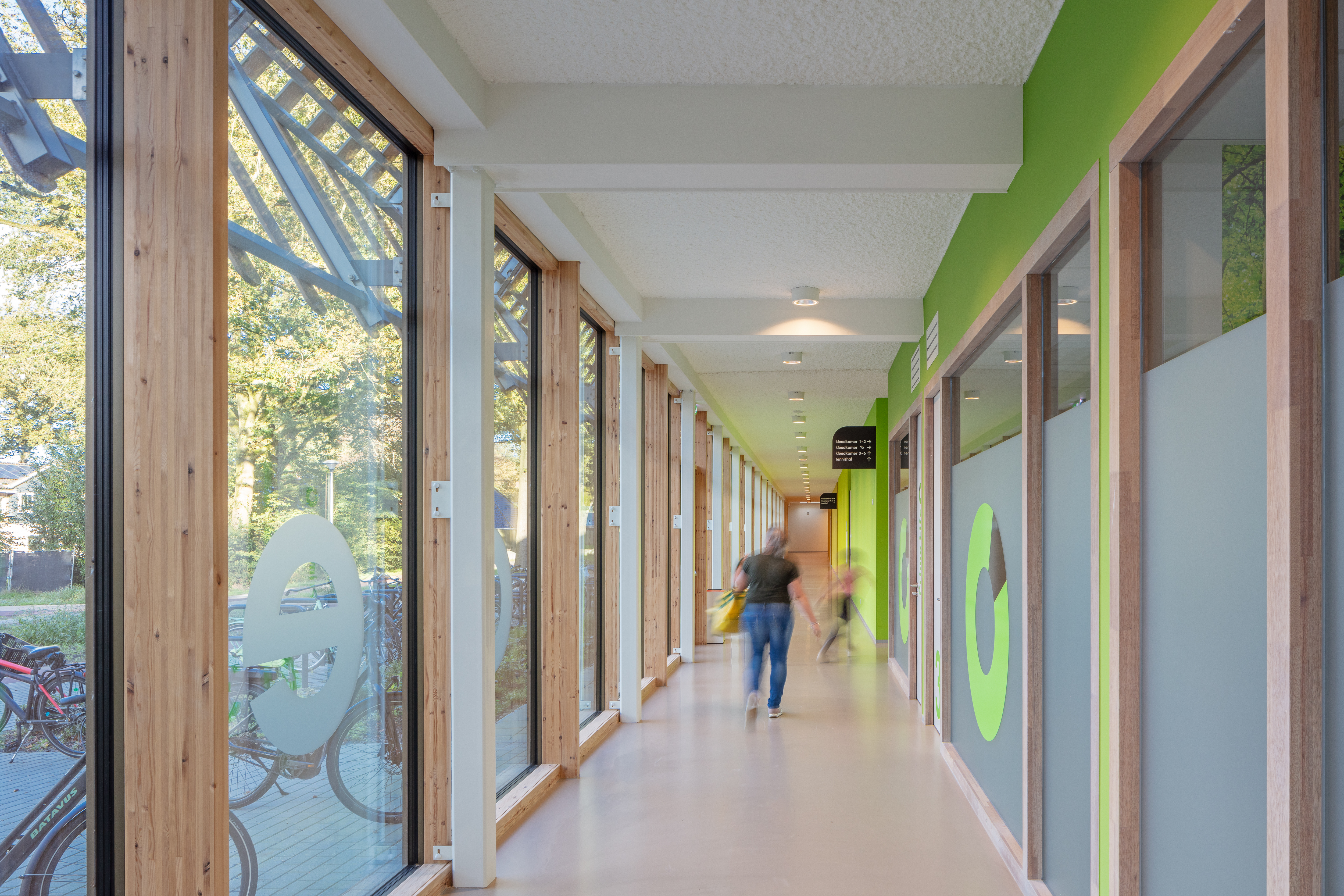 Gang langs sportzaal met uitkijk naar buiten