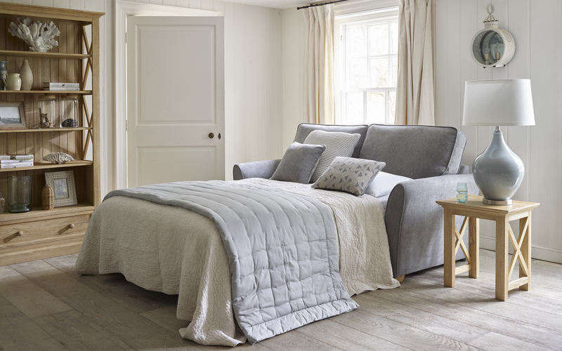 Grey fabric sofa bed in a neutral toned room