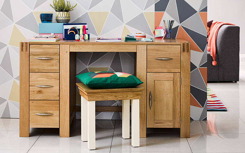oak computer desk against grey and coloured geometric pattern
