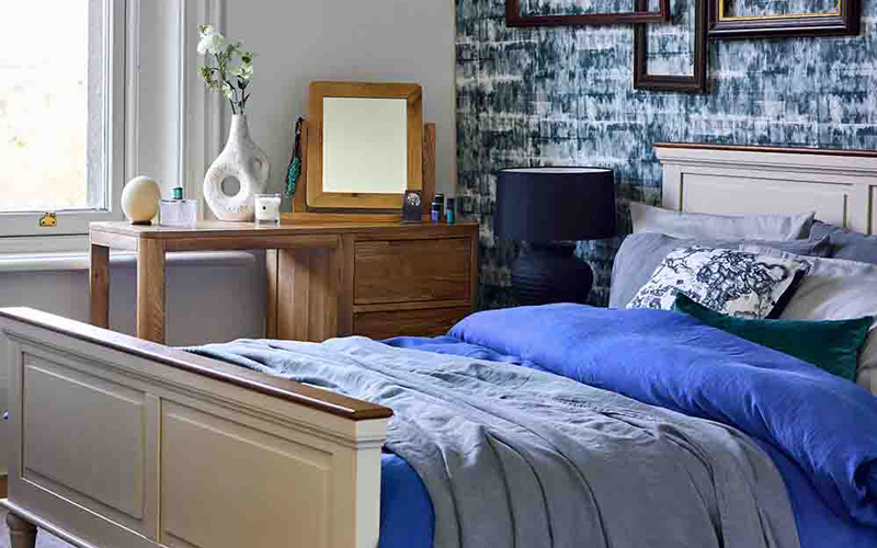 oak dressing table and white painted bed in blue bedroom