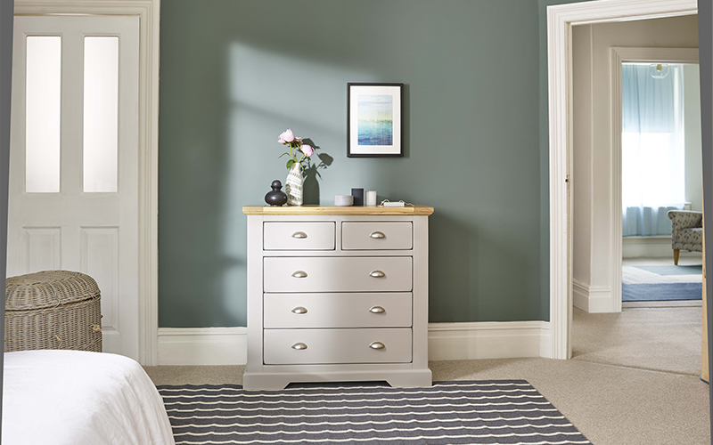 grey painted chest of drawers in green bedroom