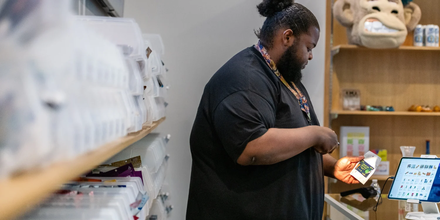 Budtender reviewing product at the POS counter