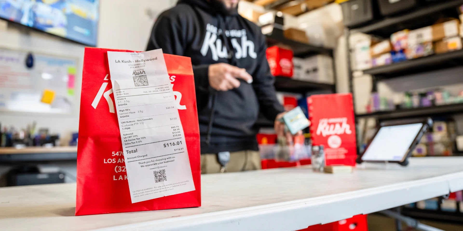 A packed cannabis delivery order waiting on the counter in a dispensary back-of-house area.