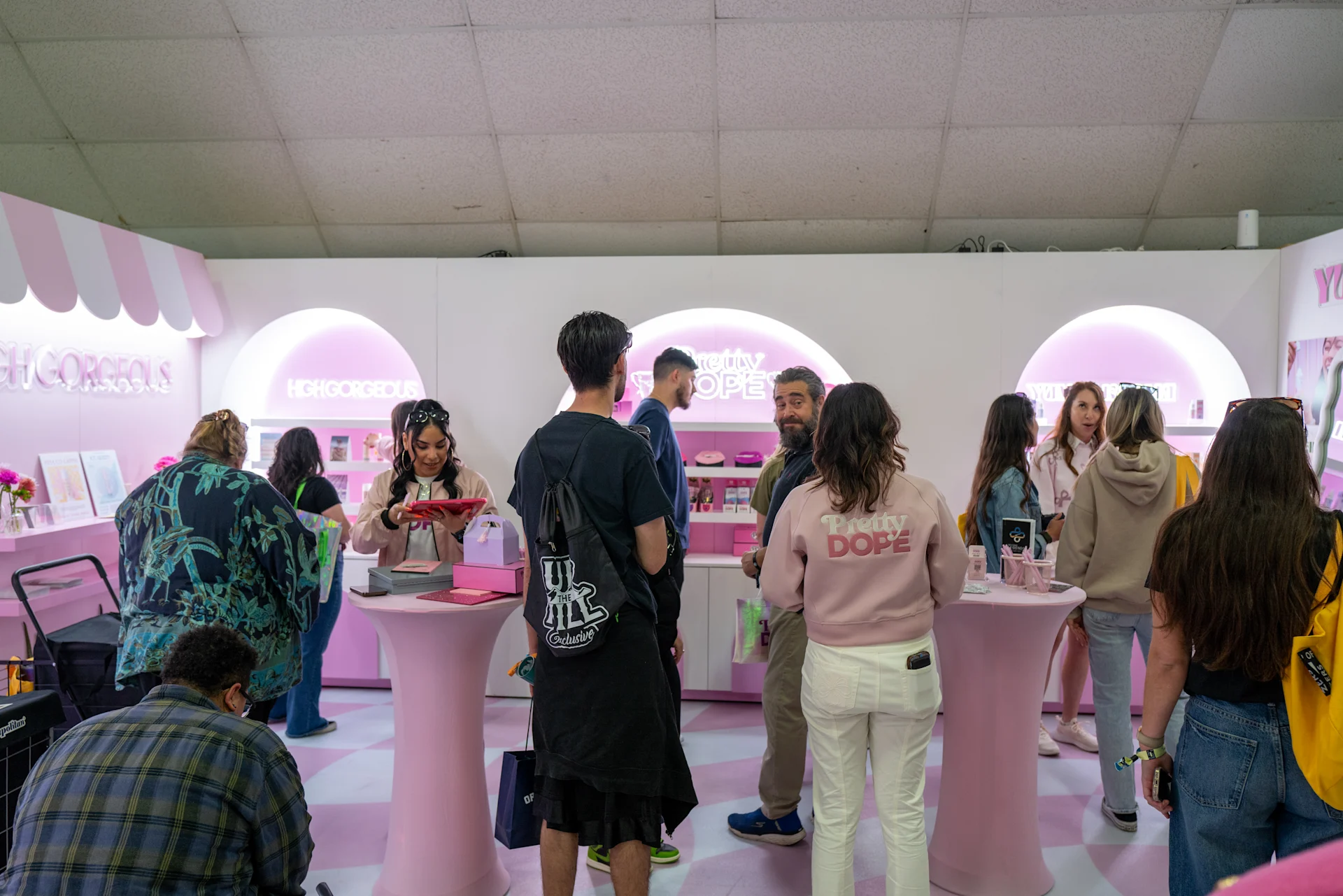 Attendees gathered around tasting tables at a brand booth during Hall of Flowers