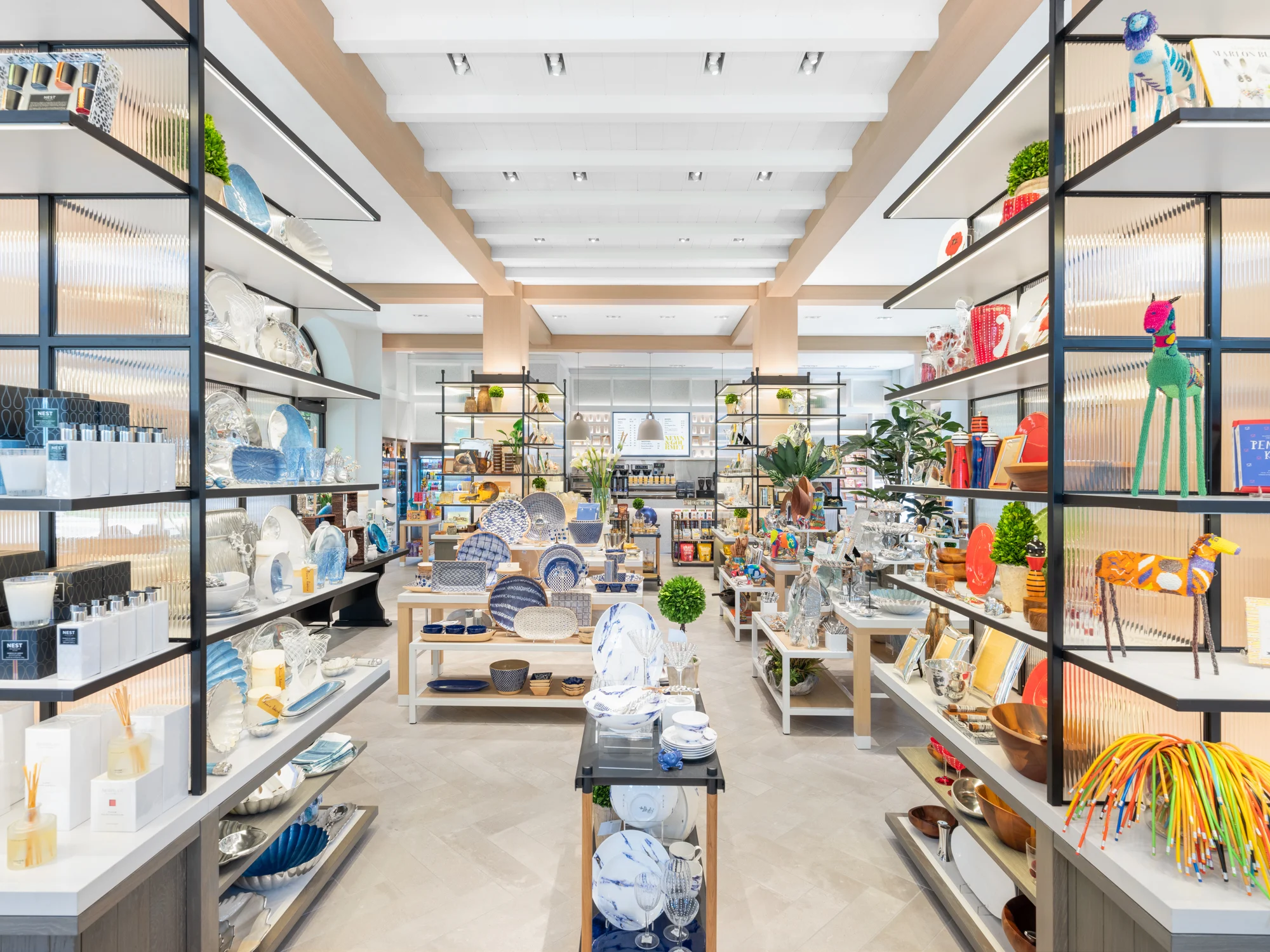 Modern retail store interior with shelving displaying colorful home goods and decor items.