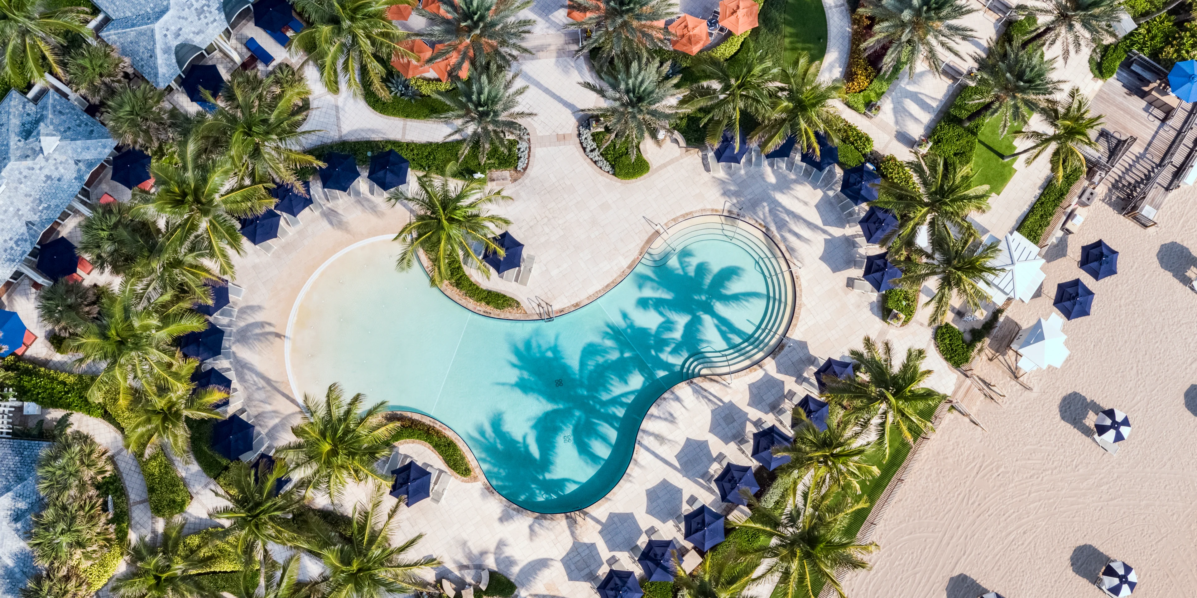 Aerial view of The Breakers oceanfront pool deck and cabanas with the Atlantic in the background.