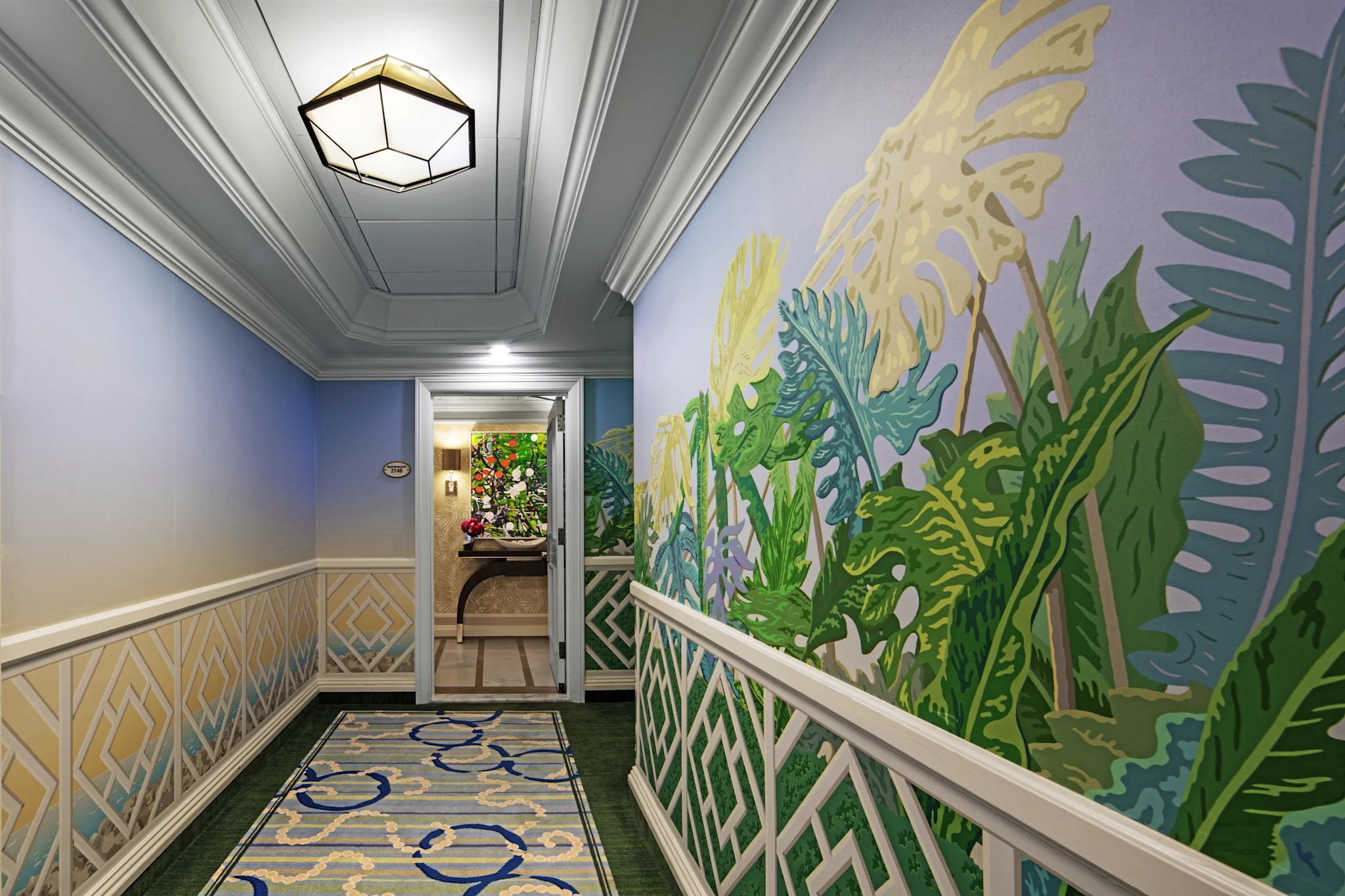 Elegant hallway with tropical leaf mural, geometric ceiling light, and patterned carpet runner.