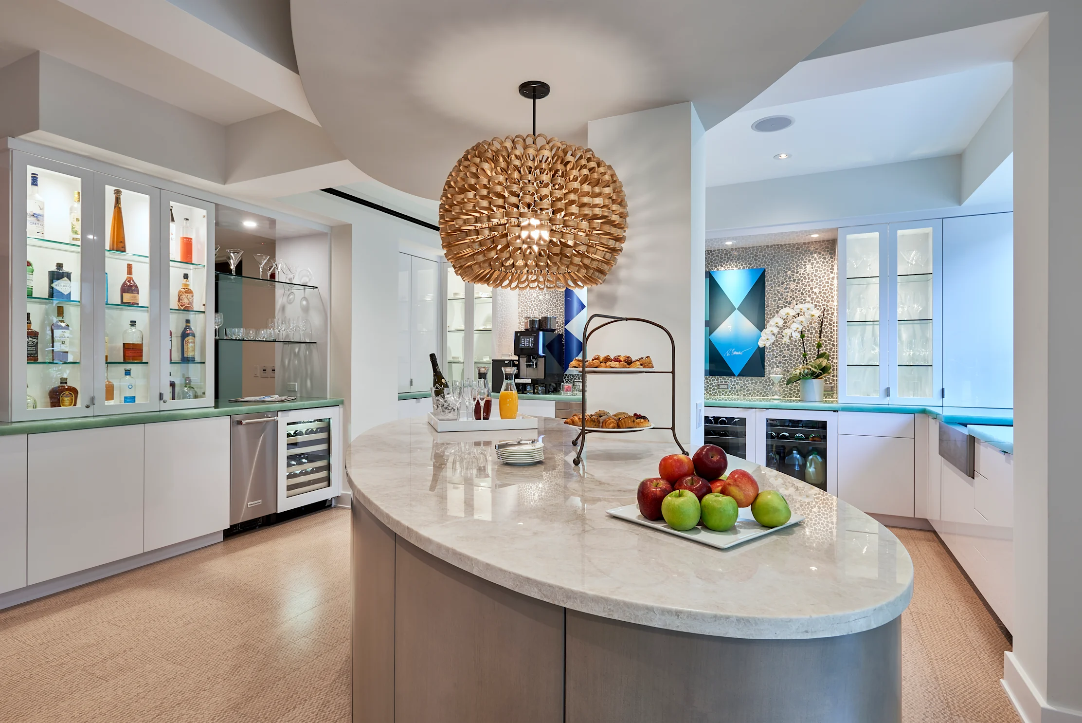 Modern white kitchen with curved island, spherical pendant light, and glass-front bar cabinets.