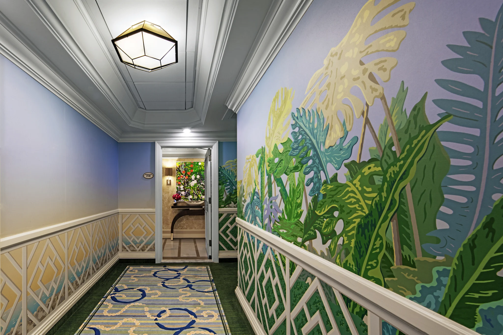 Elegant hallway with tropical leaf mural, geometric ceiling light, and patterned carpet runner.