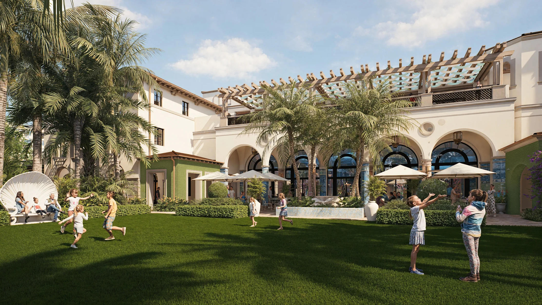 Children playing on green lawn in front of white Mediterranean-style resort with palm trees and arches.