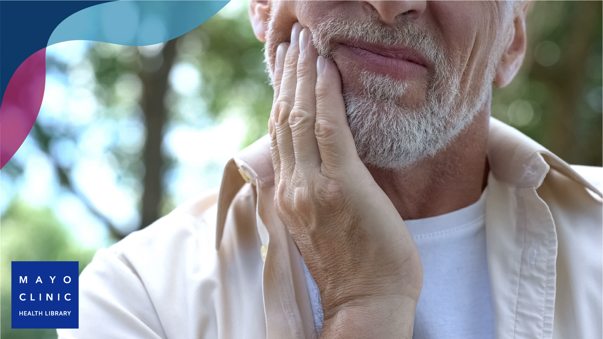 Man with hand placed on the side of his cheek, representing a sore mouth.
