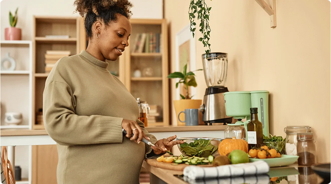 pregnant woman preparing food in kitchen
