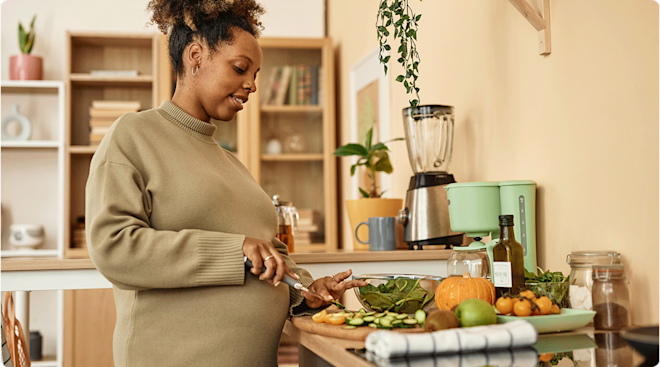 pregnant woman preparing food in kitchen