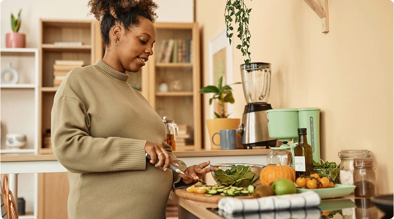 pregnant woman preparing food in kitchen