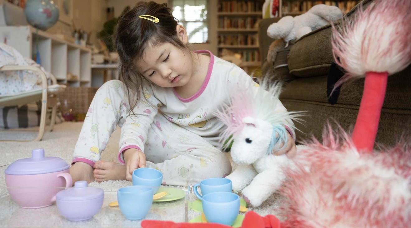 toddler playing pretend with stuffed animal