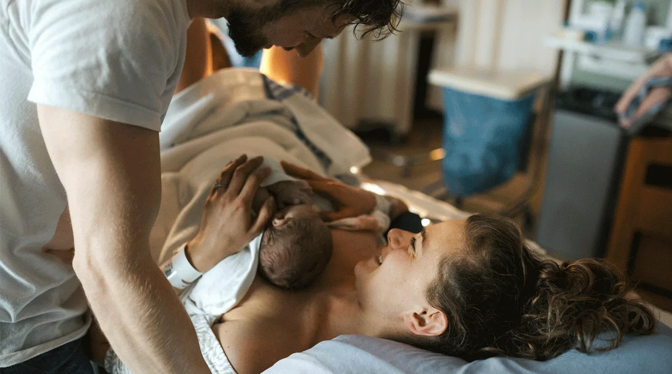mom after labor and delivery in hospital bed with newborn baby