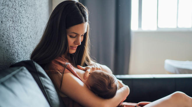 mom breastfeeds young baby 