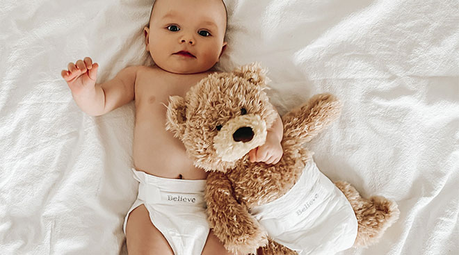Baby wearing believe diaper brand. 