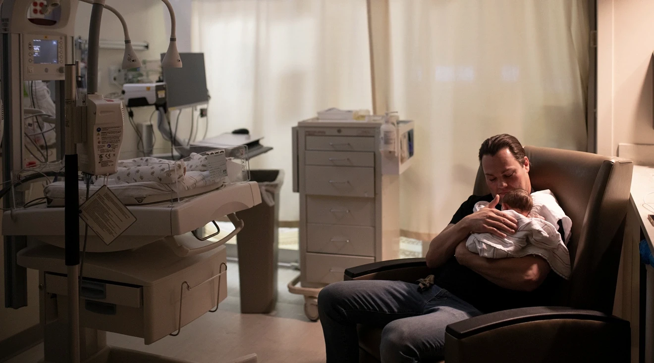 father holding baby in the NICU