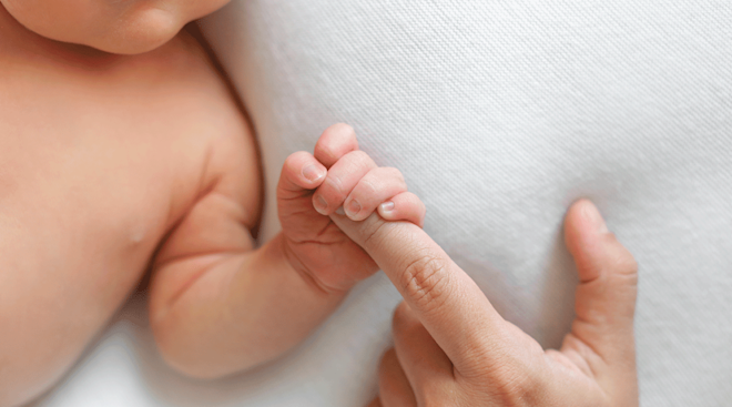 baby grasping mom's finger, palmar grasp