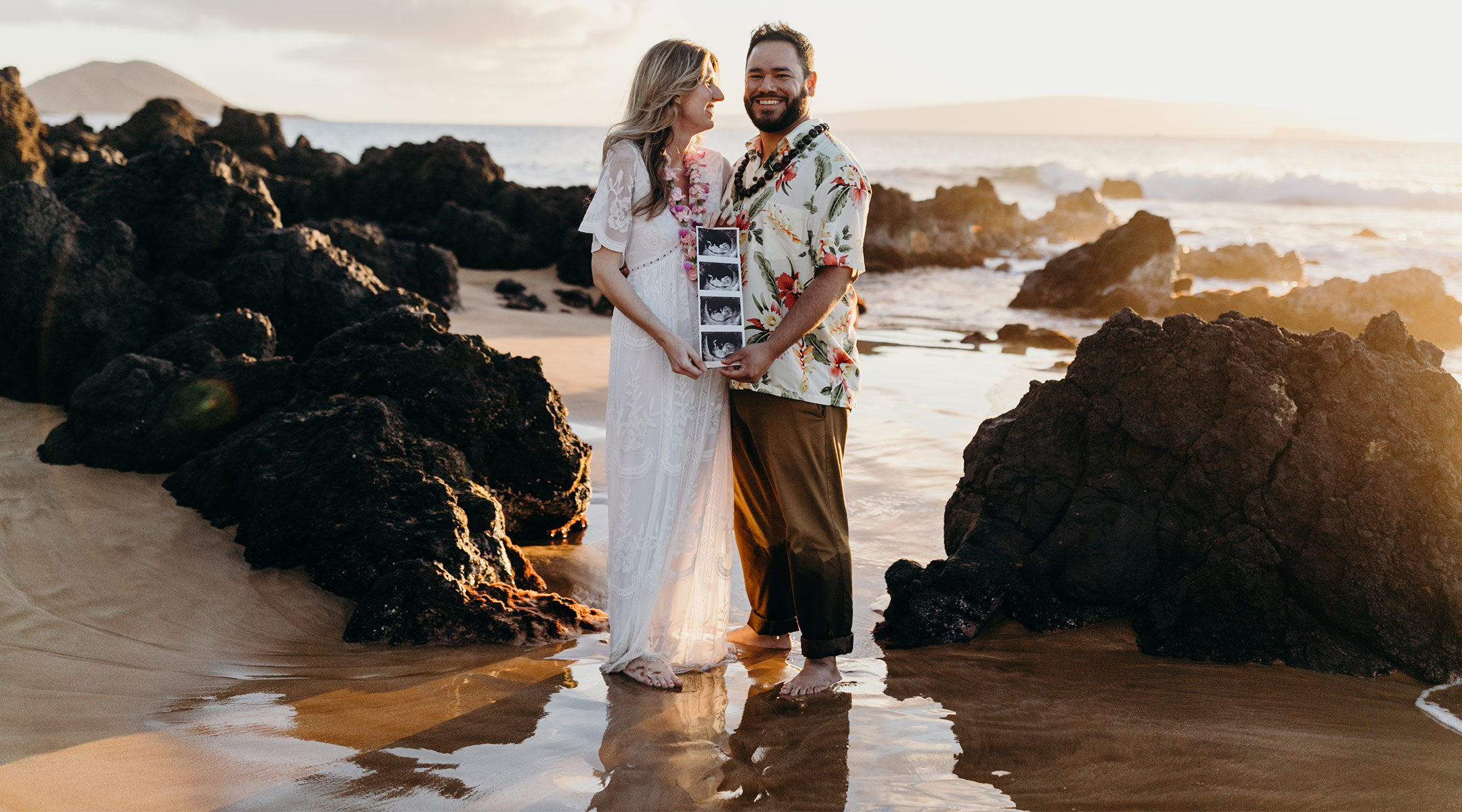 pregnant woman with her partner on babymoon in maui, hawaii