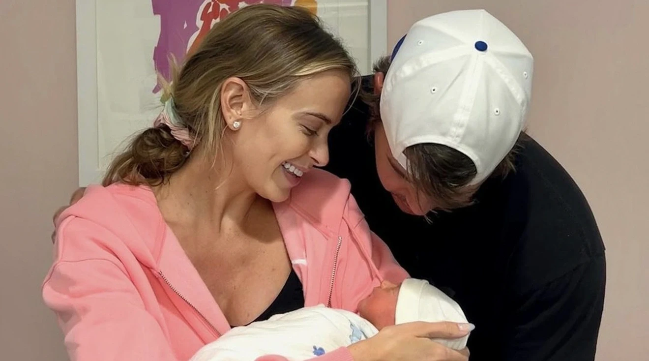 pro golfer Brooks Koepka and Jena Sims holding their newborn baby