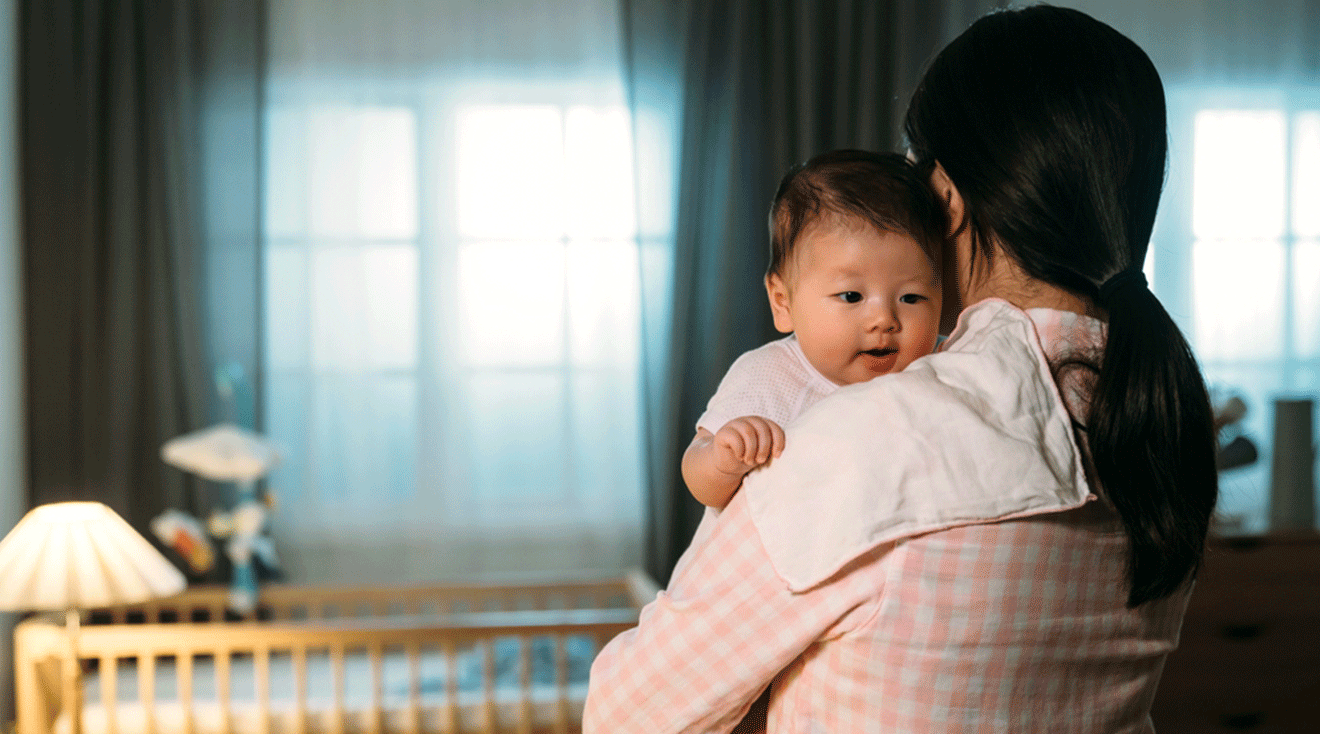 mom holding newborn baby at home at night