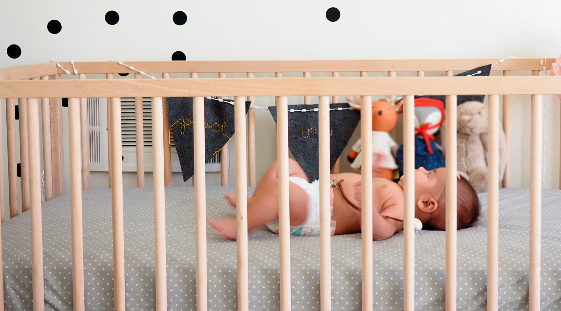 baby practicing sleep training in crib