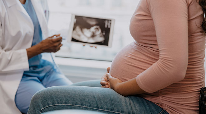 close up of pregnant woman talking to her doctor about ultrasound results