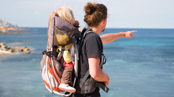 Travel tips Baby in pack with father while traveling by the sea