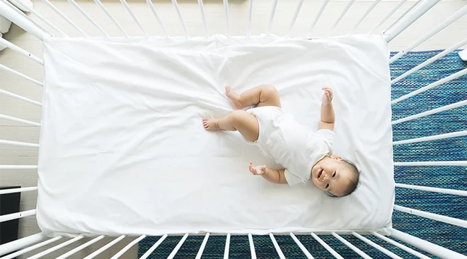 baby in crib smiling