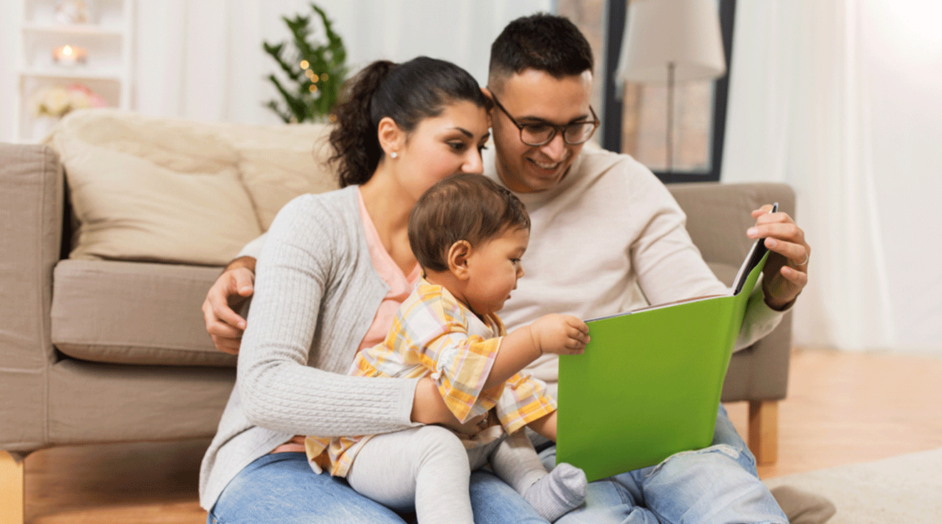 mom and dad reading book to toddler at home