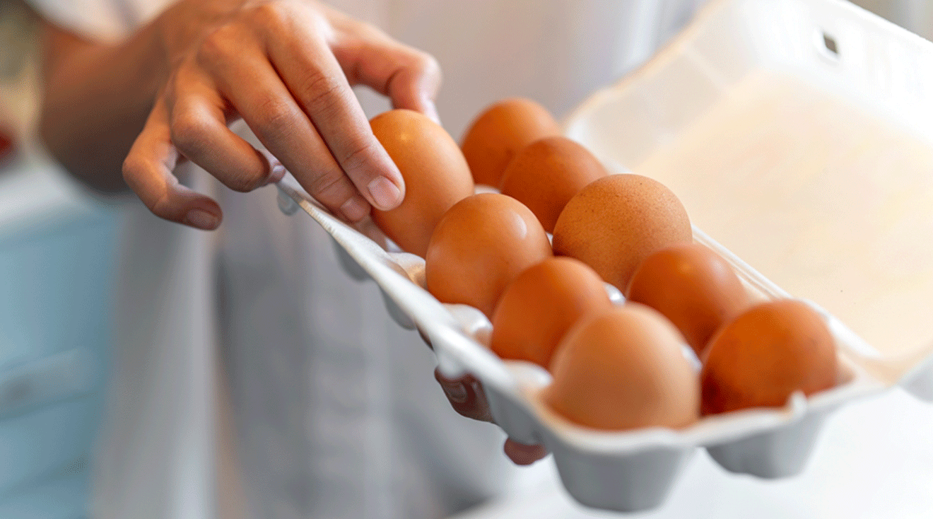 person picking up an egg out of the carton