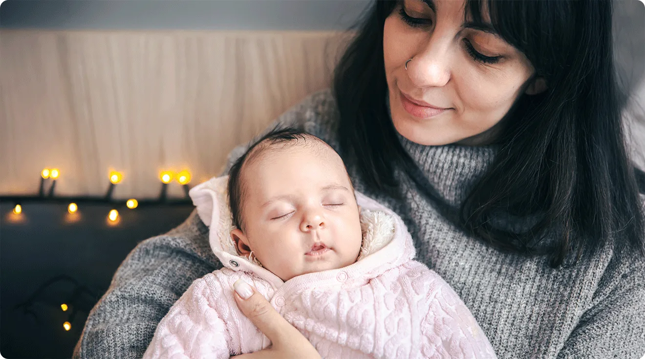 mom and newborn baby snuggled at home during winter