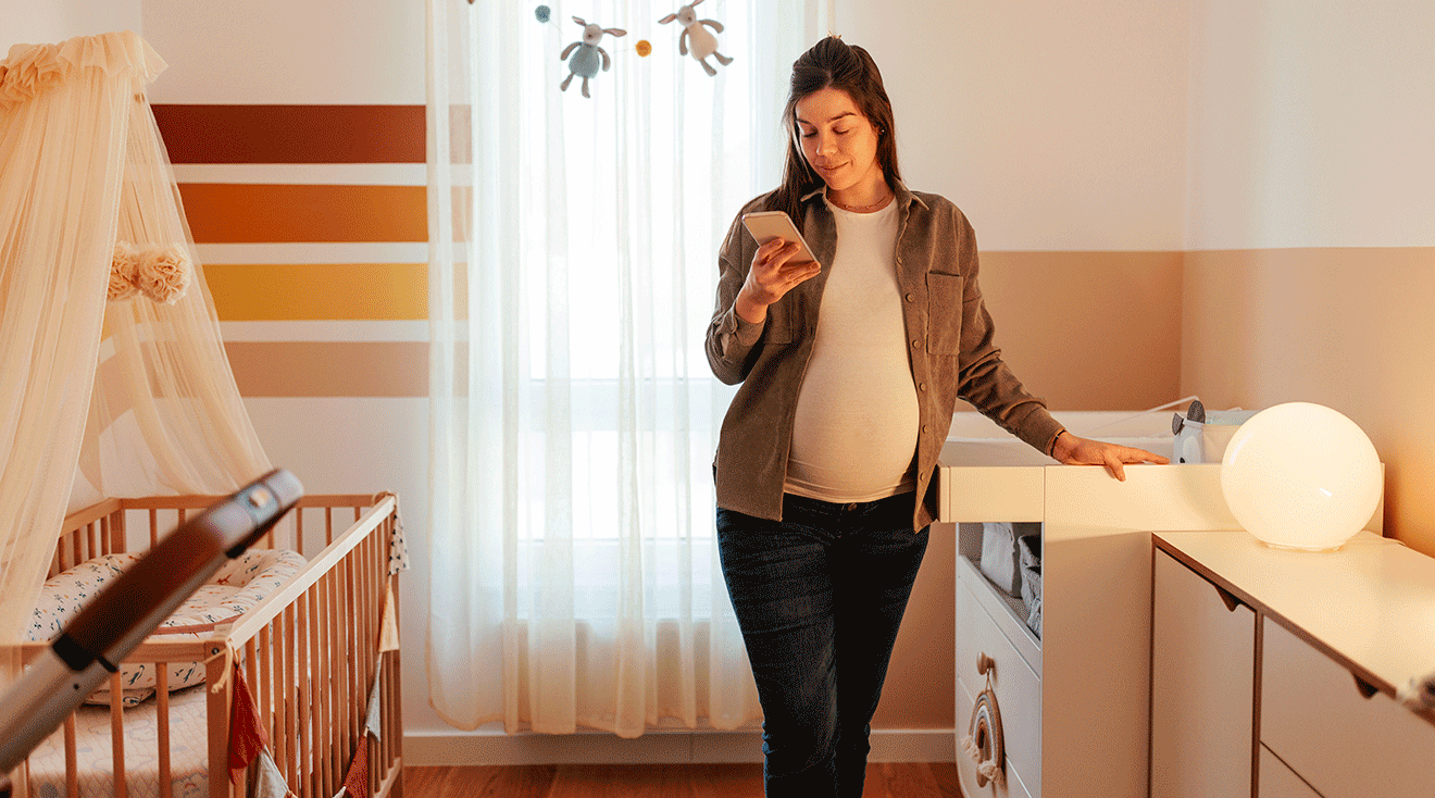 pregnant woman preparing for baby to arrive in baby's nursery room