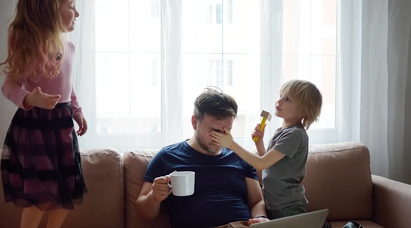 tired father overwhelmed with 2 children at home