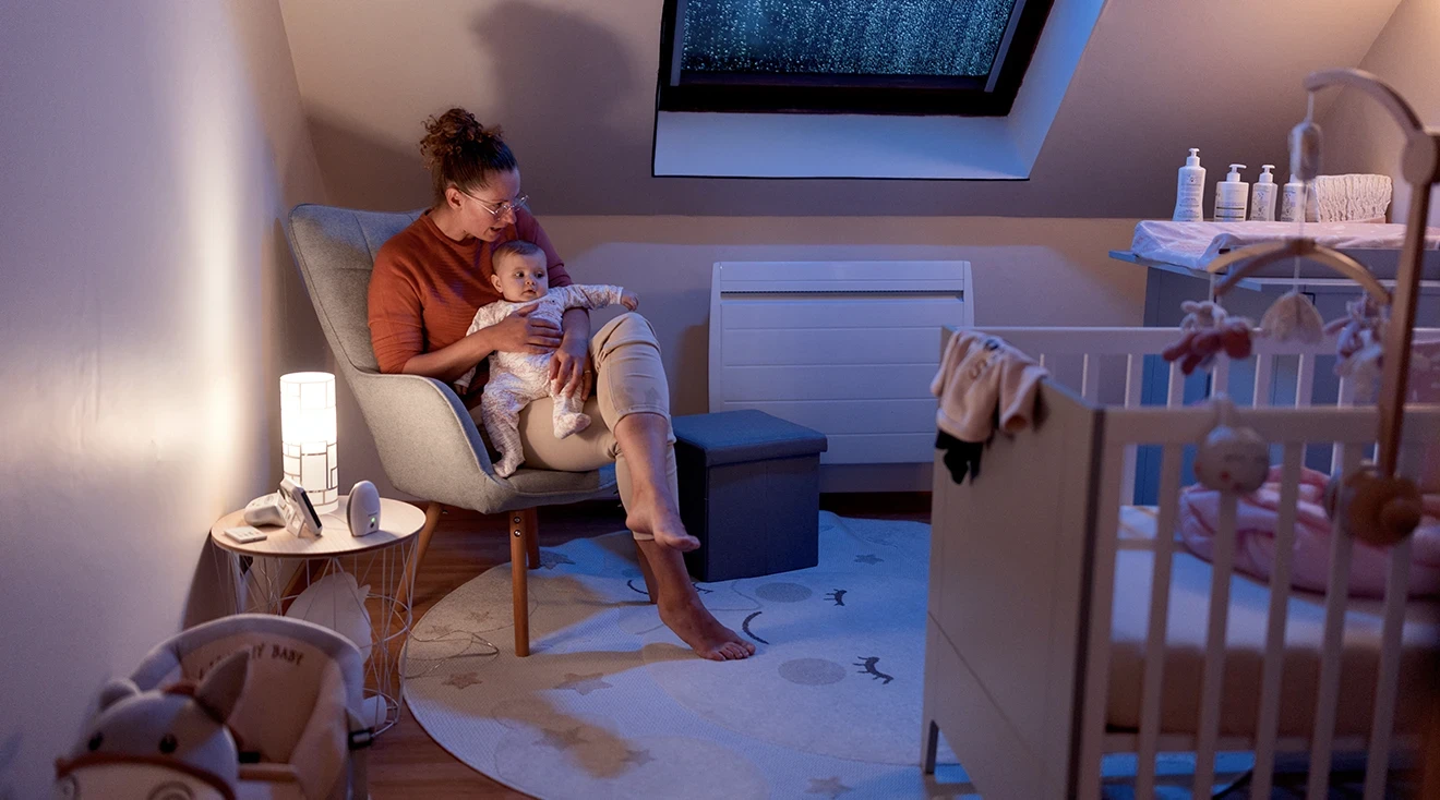 mother comforting baby at night in nursery room