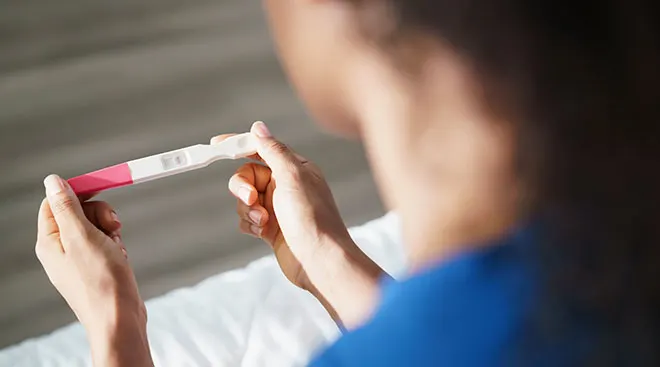 A woman's hands holding a negative pregnancy test.