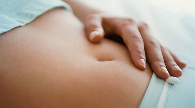 close up of woman's hand on her stomach while lying down