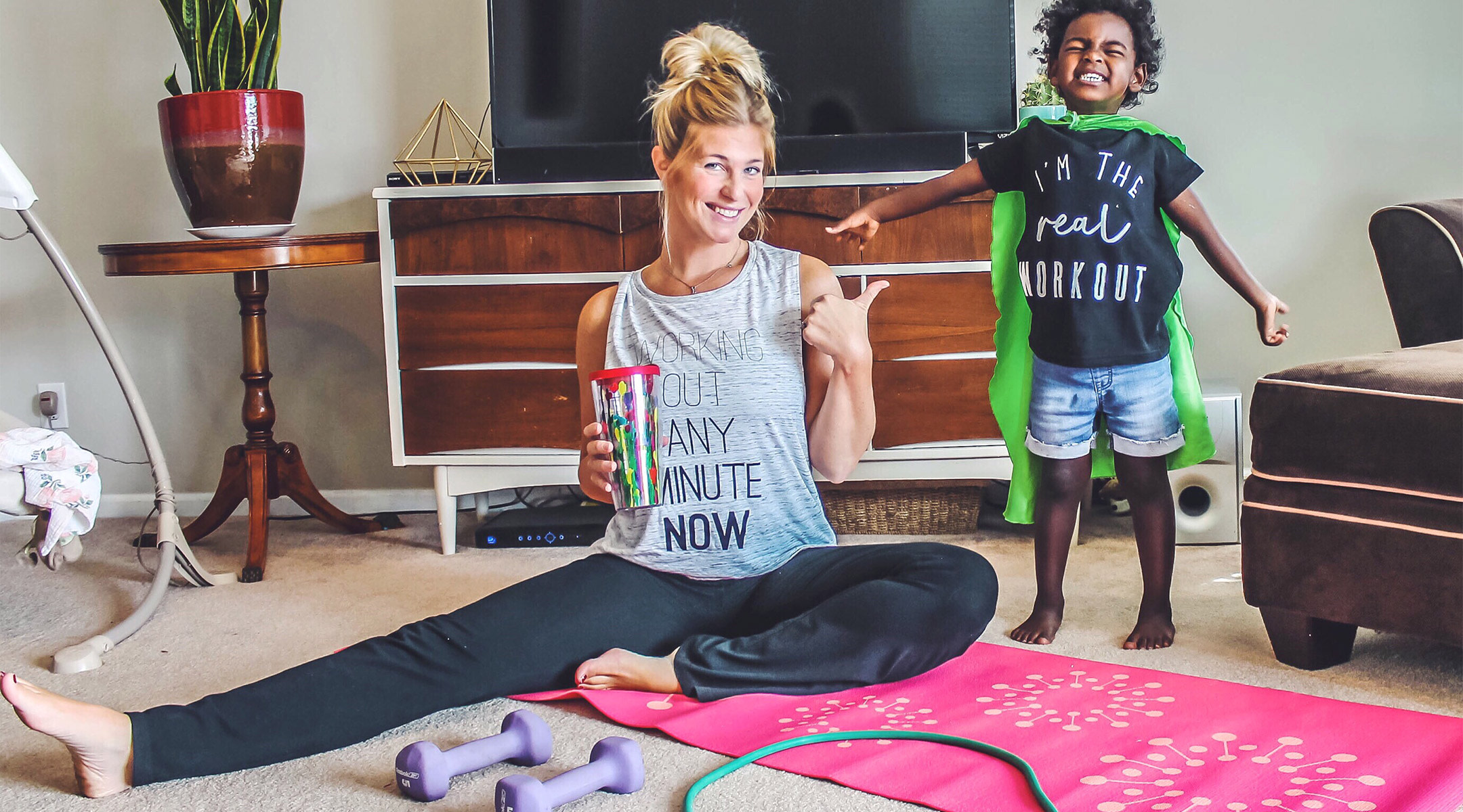 funny image of mom working out at home with her kid wearing cape
