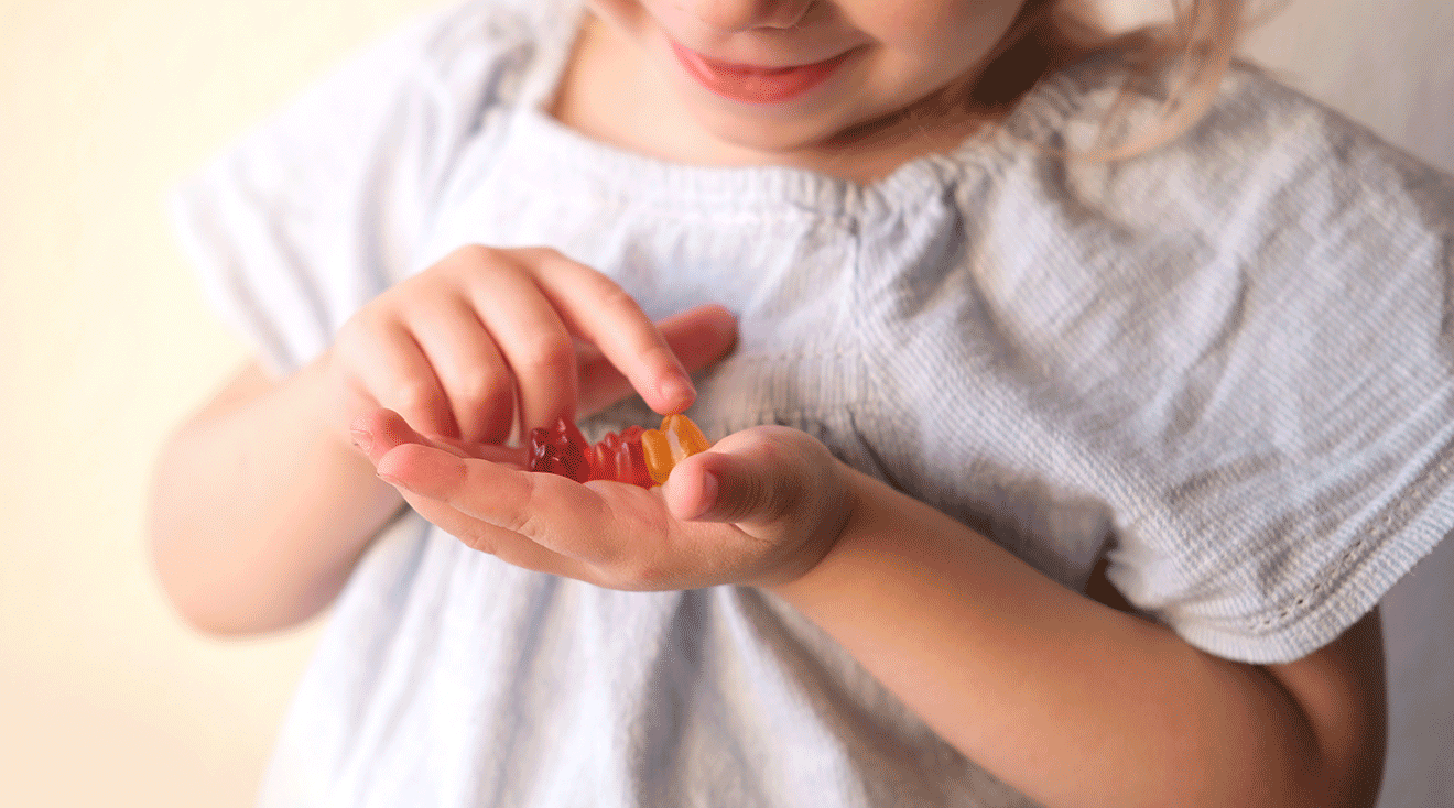 young child holding gummies