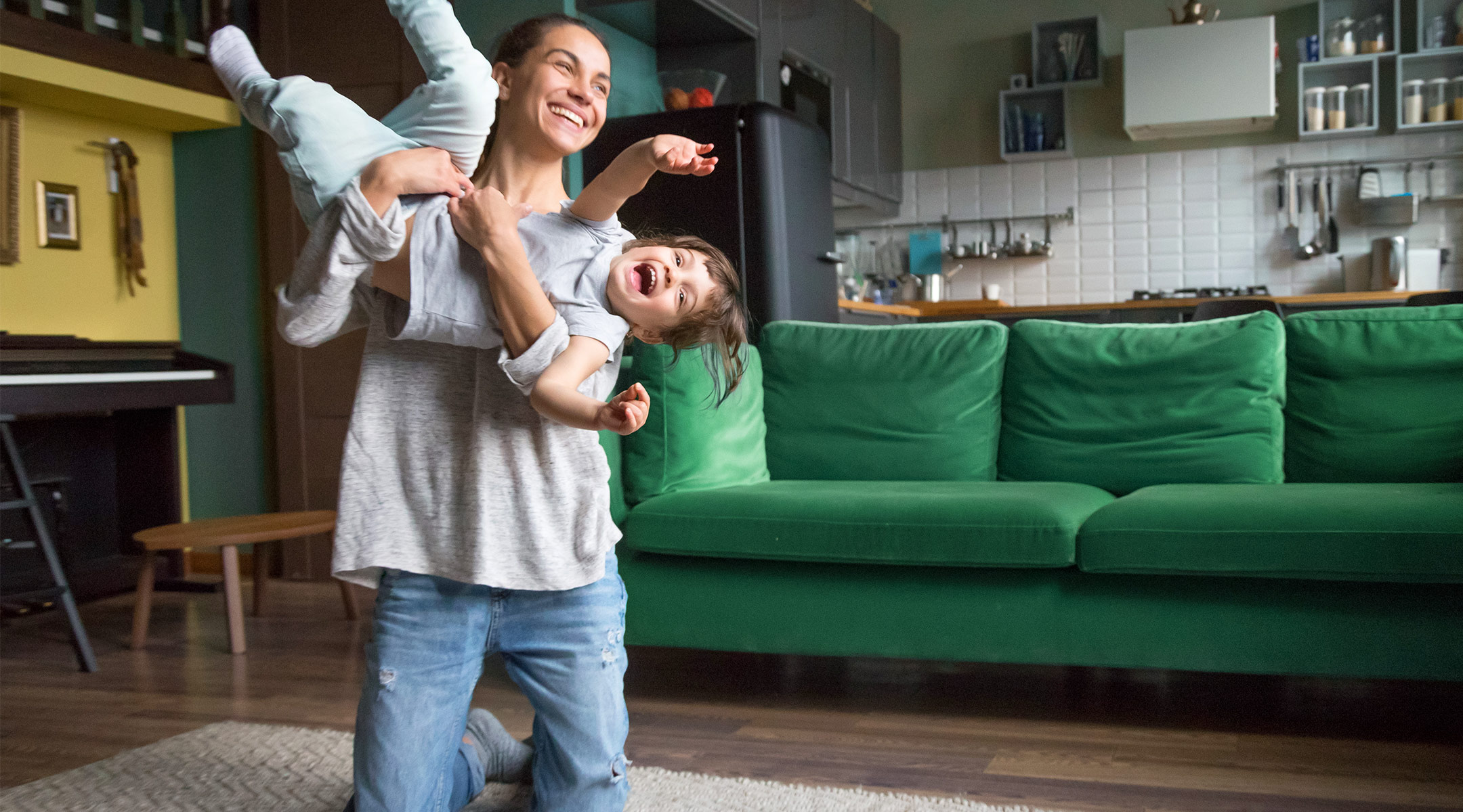 caregiver lifting up and playing with toddler