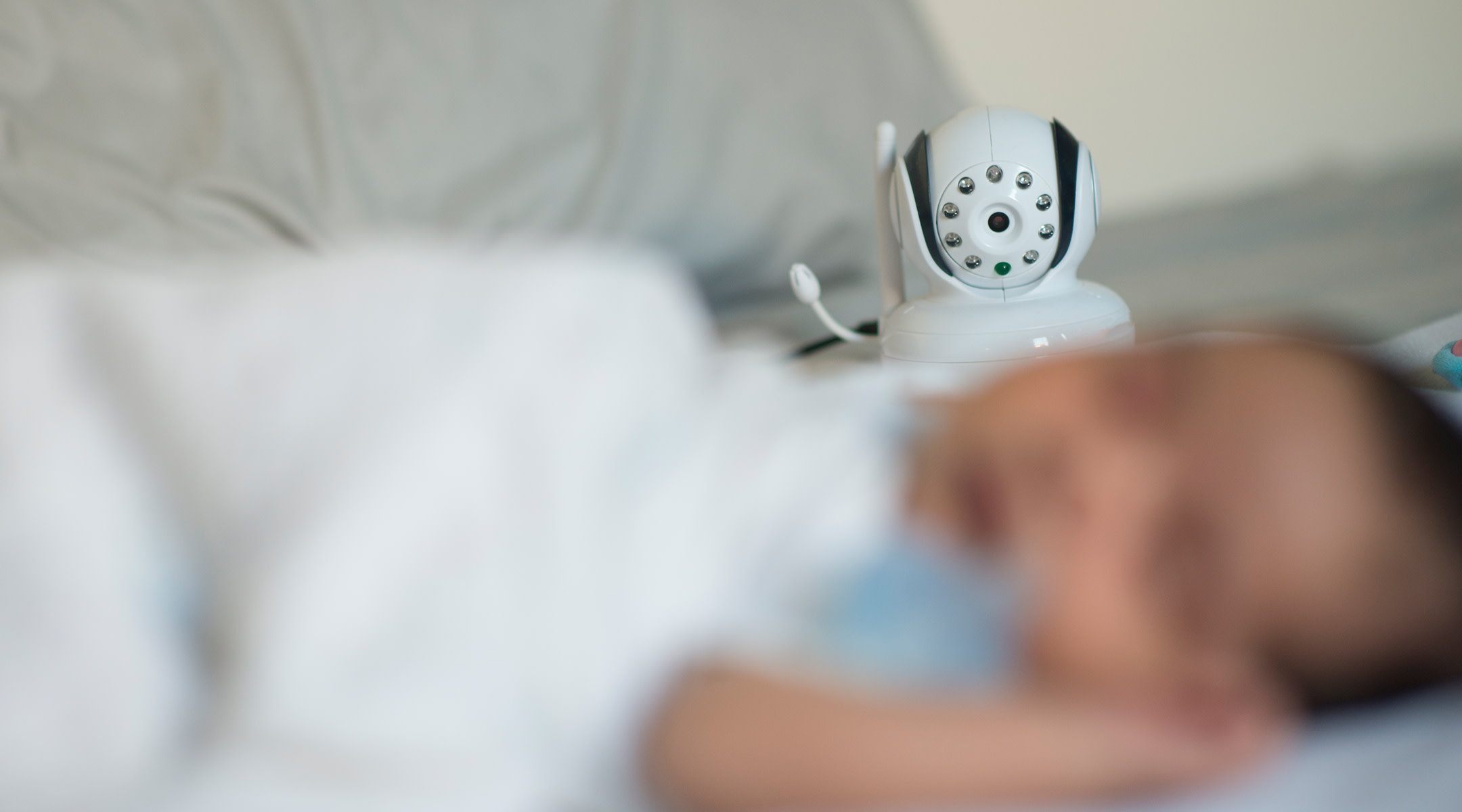 Blurred image of a baby sleeping in view of a baby monitor