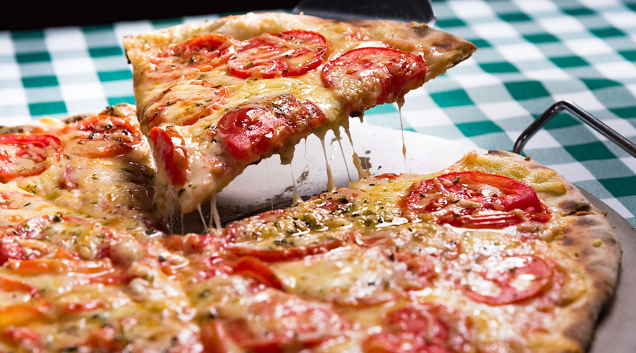 pizza pie with someone taking a slice