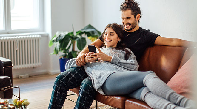 couple on the couch looking at phone screen