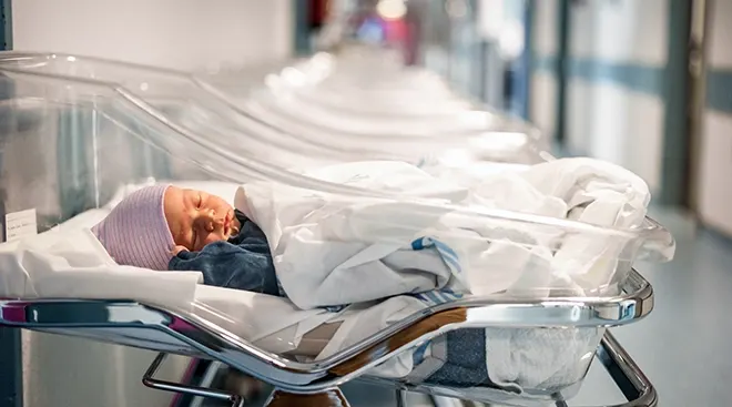 newborn baby in hospital bassinet