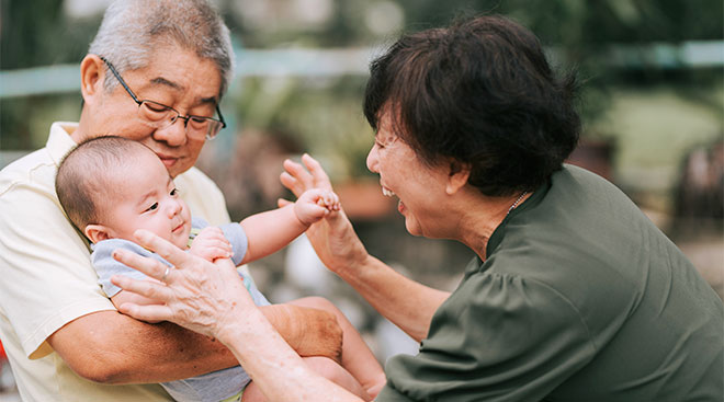 Grandparents happily playing with their grand baby.