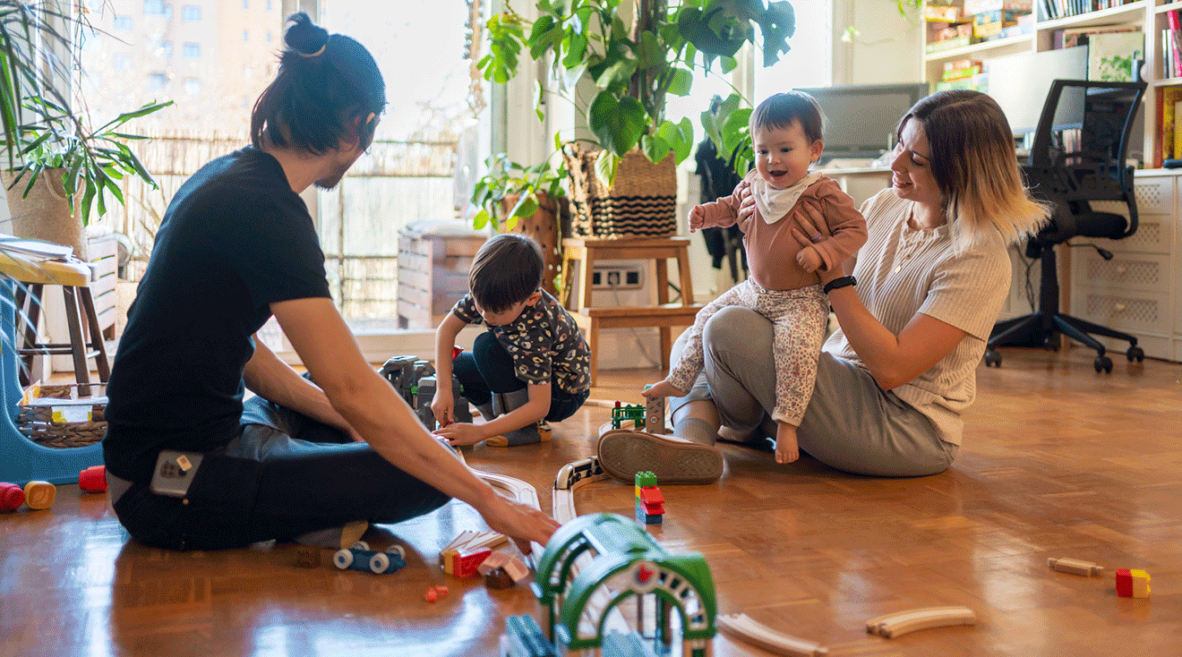 family with 2 toddlers playing with toys at home