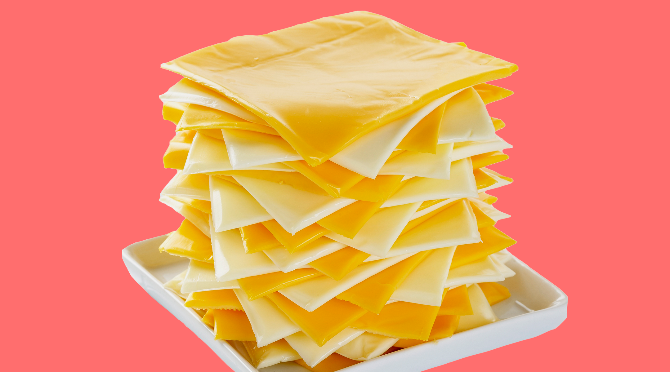 stack of sliced cheese on coral background