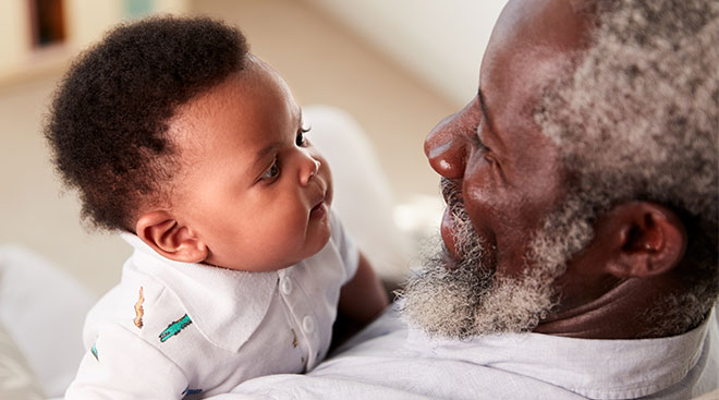 Grandpa staring lovingly at his baby grandchild. 